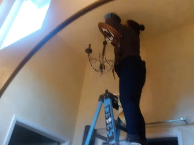 Electrician installing a chandelier in a San Juan Capistrano residence